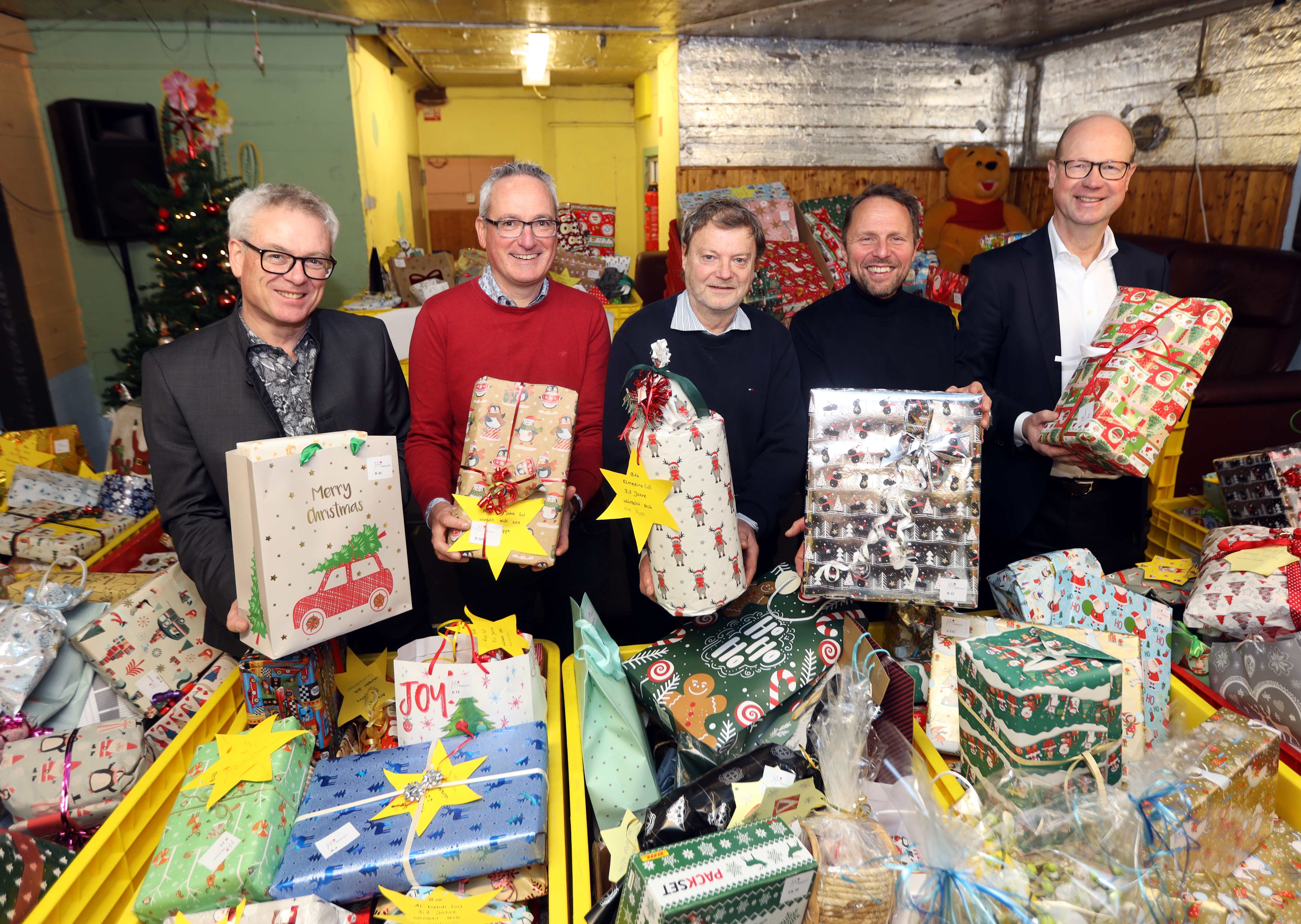 Das Bild zeigt inmitten eines Teils der über 900 Geschenke (von links nach rechts): Klaus Niesen (Geschäftsführer der Peter Niesen GmbH & Co. Internationale Möbelspedition KG), Markus Kalcker (Prokurist der Peter Niesen GmbH & Co. Internationale Möbelspedition KG), Reiner Hilken (Netzwerk Kinderarmut), Uwe Richrath (stv. Vorsitzender des Stiftungsvorstandes) und Markus Grawe (Vorsitzender des Stiftungsvorstandes)